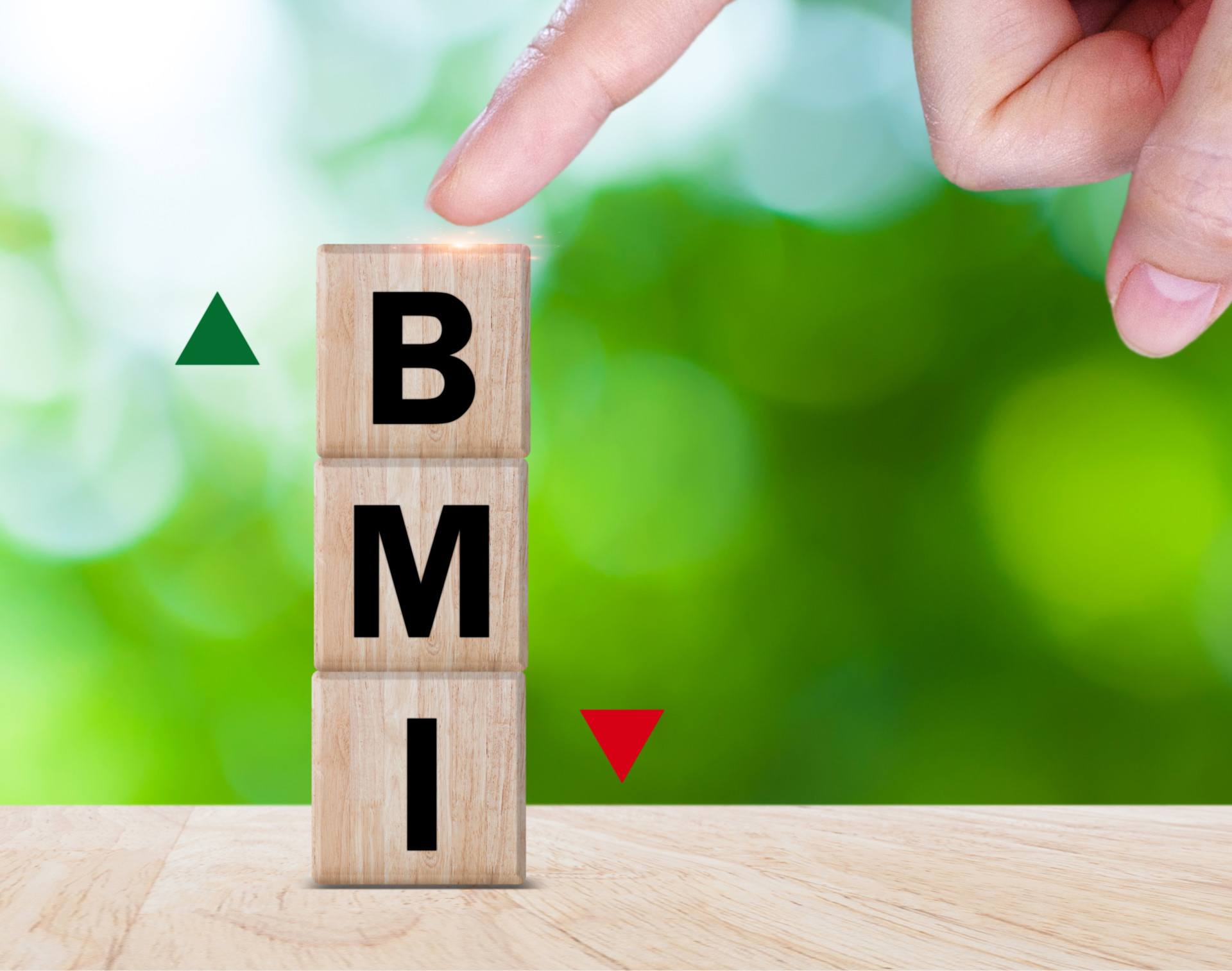 Buchstaben BMI auf Holzklötzen übereinander und Fingerzeig auf das obenstehende B
